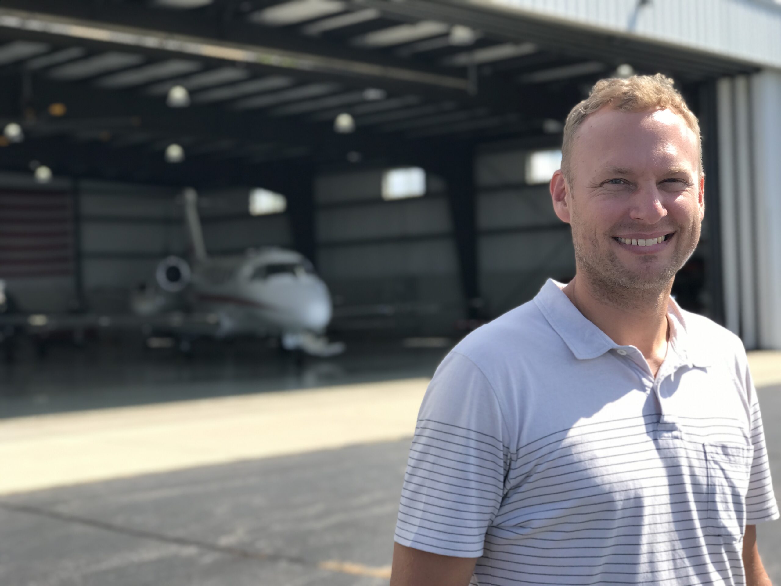 CEO & Co-Founder, Mark Becker in front of the airplane hangar the business started in, in Burlington, WI.